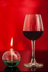 A couple of red wine glasses and  oil lantern