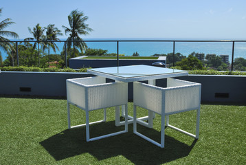 Terrace lounge with white rattan armchairs and seaview in a luxu