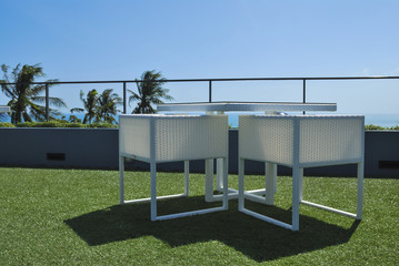 Terrace lounge with white rattan armchairs and seaview in a luxu