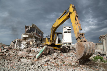 Bulldozer removes the debris from demolition of old buildings