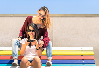 Best friends enjoying time together outdoors with smartphone