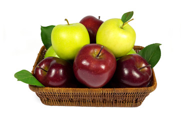 Fresh red and green apples with leaves in wicker basket isolated