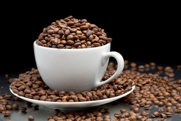 Cup and saucer full of coffee beans