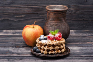 Waffles with raspberries, blueberries and milk. Breakfast