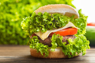Cheeseburger with lettuce, onions and tomato in a sesame bun