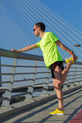 Stretching after jogging on a bridge.