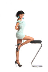 Fototapeta premium Woman with fashion hairstyle poses at studio on bar stool