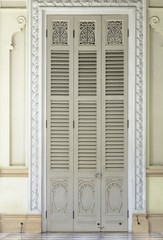 Ancient yellow carving wooden door of Thai temple