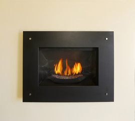 Modern built-in fireplace with fire in black color