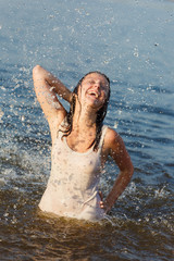he young woman costs in water in a white vest