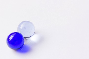 Two blue and clear glass marbles - Lower left