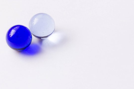Two blue and clear glass marbles - Upper left