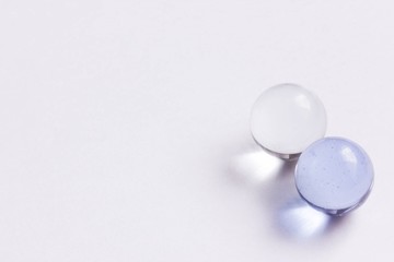 Two light blue and clear glass marbles - Lower right