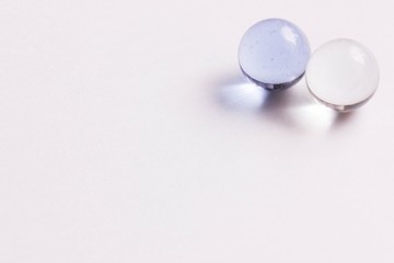Two light blue and clear glass marbles - Upper right