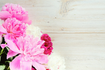 colorful peonies on white wooden surface
