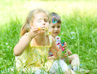 Girl and boy blowing soap bubbles