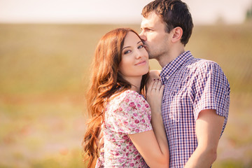 Portrait of a young couple posing in summer in the field