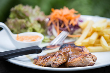 juicy grilled pork chop (neck cut) with greens