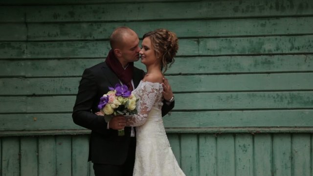 Beautiful wedding couple near a blue wall
