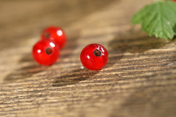 Fresh red currant in bowl on wooden background.