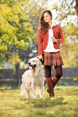 Beautiful girl walking her dog in park