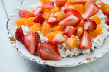 Cottage cheese with fresh sliced fruits on a glass plate