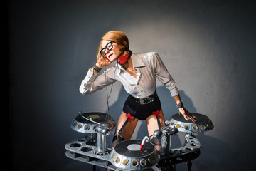 Obraz na płótnie Canvas DJ girl in sexy outfit playing on vinyl