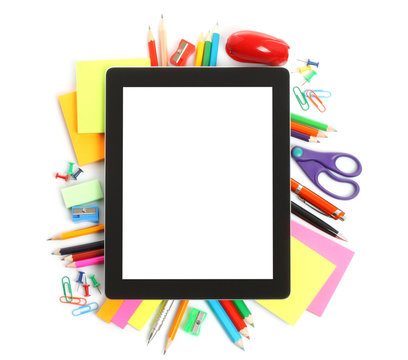 Tablet PC with school office supplies on white background .