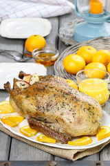 Roasted duck with oranges on wooden table