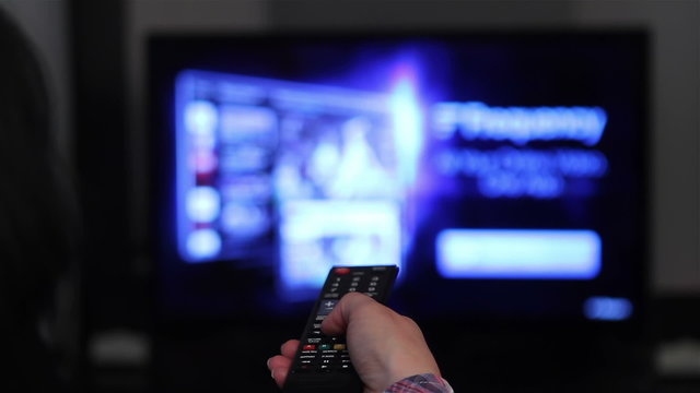 Smart tv apps and young woman hand pressing remote control