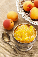 Bowl of apricot jam and ripe apricots in the background