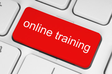 Red online training button on white keyboard background.