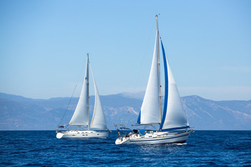 Fototapeta na wymiar Two sailboats on peaceful still waters in a harbor.