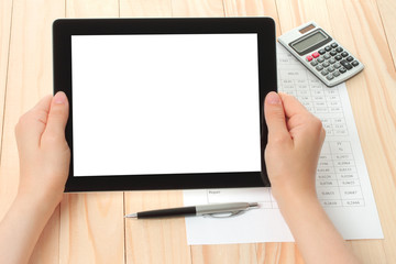 Hands hold tablet PC on wooden background .