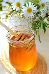 Obraz na płótnie Canvas Jar full of honey and chamomile