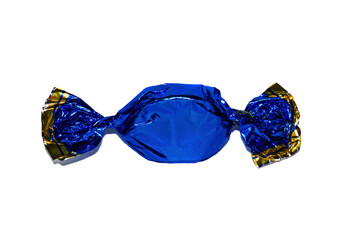 One candy in a dark blue shiny paper wrapper closeup