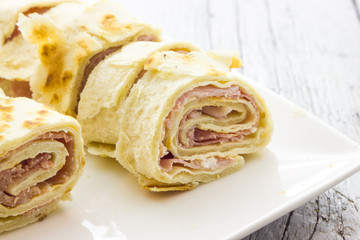 Roll of piadina with ham and cheese
