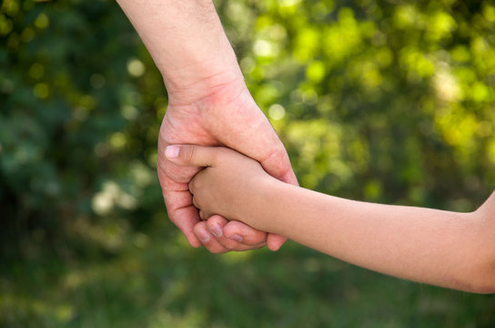 Child and parent holding hands