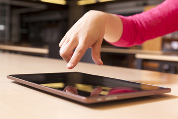 Hand pointing to tablet computer in library