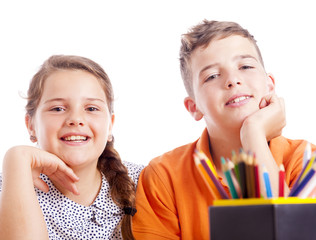 Portrait of two school kids at the desk, isolated on white backg
