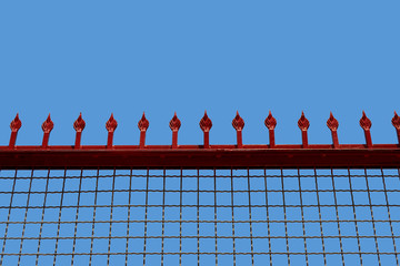 lattice with peaks against the sky female college fence