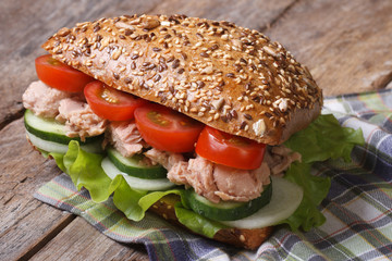 tasty sandwich with tuna and vegetables closeup on table