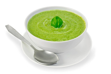 Soup puree with spinach in bowl and spoon