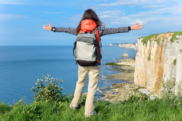 Woman hiking and looking at beautiful sea and rocks view