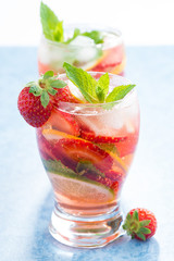 cocktail with fresh strawberries and citrus in glasses, close-up