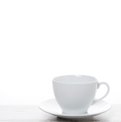 empty white coffee cup on a white table and space for text
