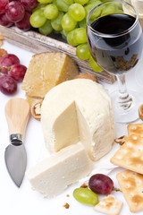 fresh cheese, crackers, grapes and a glass of wine, top view