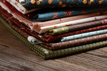 heap of cloth fabrics on wooden table