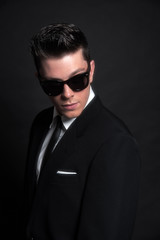 Fototapeta premium Retro fifties fashion man wearing black sunglasses with suit and