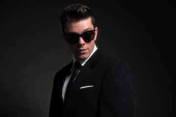 Fototapeta premium Retro fifties fashion man wearing black sunglasses with suit and